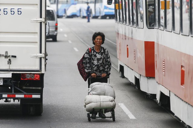 
Một người phụ nữ đẩy xe hàng giữa một con đường đông đúc ở trung tâm Bình Nhưỡng ngày 8.10.
