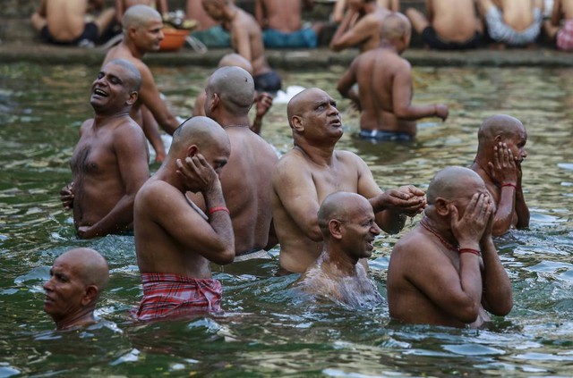 
Người Hindu cầu nguyện khi ngâm mình dưới dòng sông để tưởng nhớ linh hồn tổ tiên trong lễ Mahalaya ở ở Mumbai, Ấn Độ.

