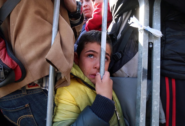 Một cậu bé di cư ứa nước mắt trong khi chờ đợi ở Sentilj, Slovenia để băng qua biên giới vào nước Áo