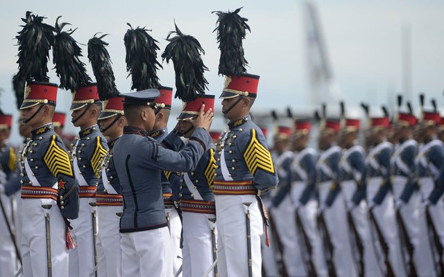 Một chỉ huy Philippines chỉnh lại mũ cho thành viên của đội danh dự trước giờ diễn ra lễ kỷ niệm.
