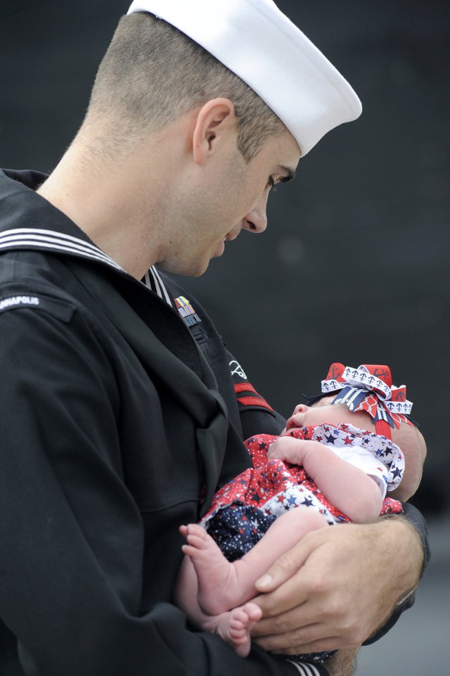 Thủy thủ Willian Wade ẵm đứa con gái của mình lần đầu tiên sau khi tàu ngầm của anh ta trở về căn cứ New London.