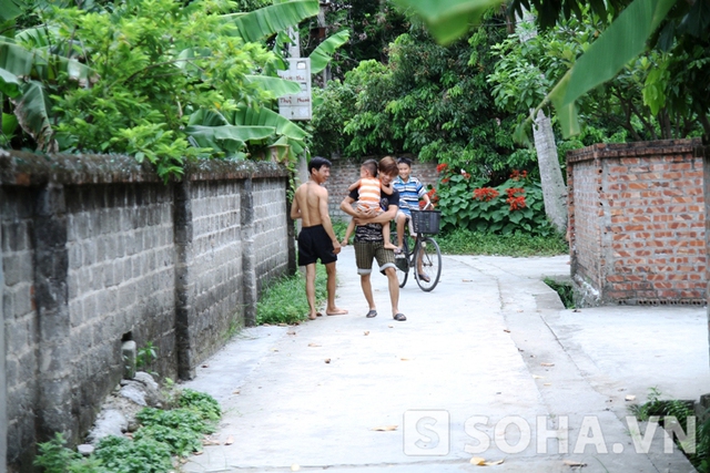 Buổi chiều, 2 chú cháu bế nhau ra xóm chơi và trò chuyện với hàng xóm láng giềng