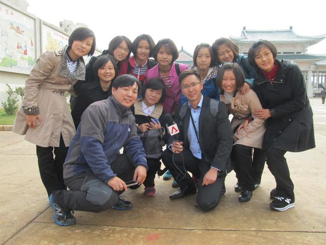 Nhà báo Jeremy Koh (cầm míc) chụp ảnh cùng các cô gái địa phương.