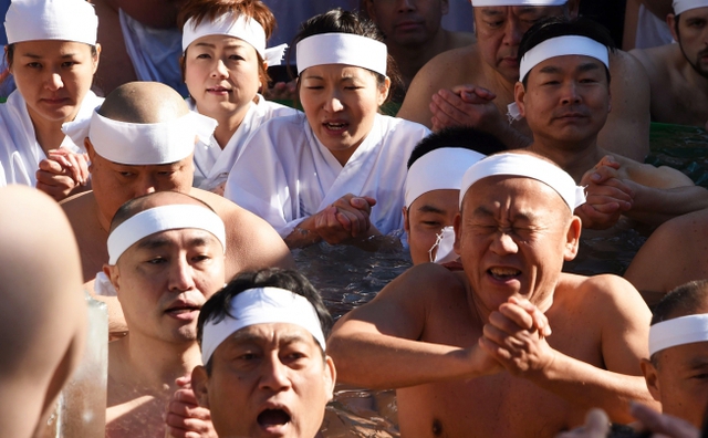 Mọi người tắm trong nước lạnh để gột sạch tội lỗi và cầu mong sức khỏe tại ngôi đền Teppozu-Inari, Tokyo, Nhật Bản.