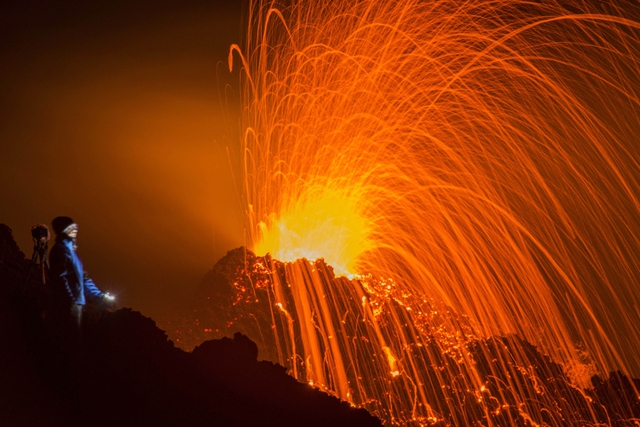 Mọi người chiêm ngưỡng cảnh tượng dung nham phun trào ra từ núi lửa Piton de la Fournaise ở La Reunion, Pháp.