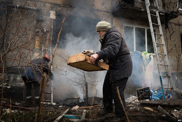 Người dân thu nhặt đồ dùng của mình từ tòa nhà bị phá hủy nặng nề sau cuộc đấu pháo giữa quân đội chính phủ Kiev và phe ly khai ở Donetsk, miền đông Ukraine.