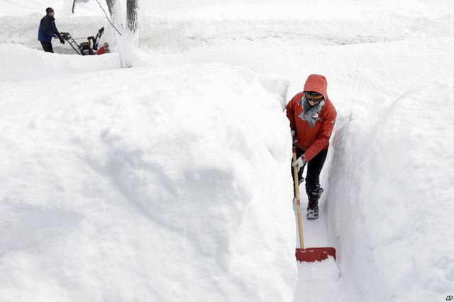 Người phụ nữ dùng xẻng dọn tuyết trước nhà cô ở Norwood, bang Massachusetts, Mỹ.