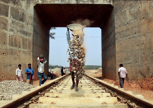 Người lao động làm việc tại công trường xây dựng đường ray tàu hỏa ở ngoại ô thành phố Agartala, Ấn Độ.