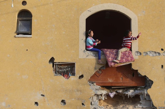 Các bé gái người Palestine chơi trên ngôi nhà bị tàn phá trong cuộc pháo kích của quân đội Israel nhằm vào thị trấn Khan Younis, Dải Gaza.