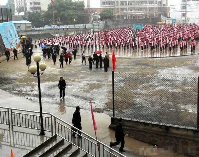 Nhà trường lo các lãnh đạo lớn tuổi sức khỏe yếu, không chịu được mưa gió nên phải che ô. Còn Ban tuyên giáo huyện giải thích rằng che ô để... bảo vệ máy chụp ảnh. Ảnh: Phượng Hoàng.