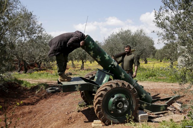 Chiến binh phiến quân kiểm tra bên trong ống phóng rocket gần thành phố Idlib, Syria.