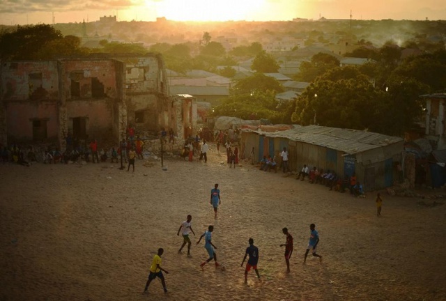 Các nam thanh niên chơi bóng đá dưới hoàng hôn ở Mogadishu, Somalia.