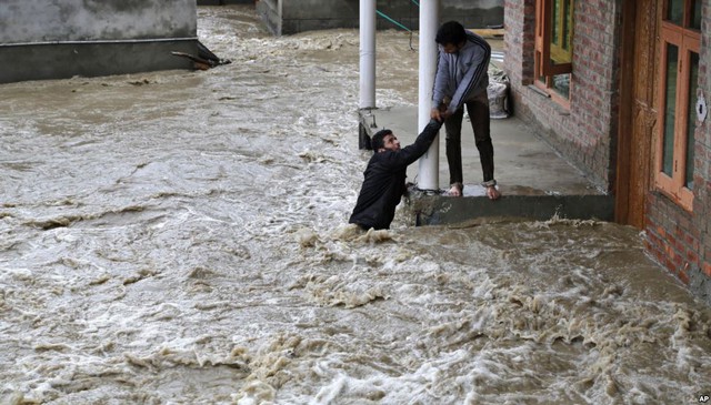 Người đàn ông đang được kéo khỏi dòng nước lũ chảy xiết ở Srinagar, Ấn Độ.