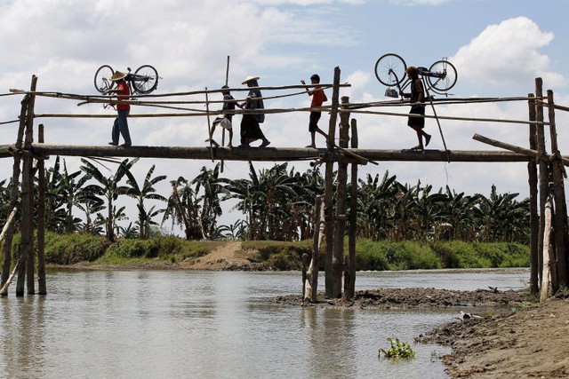 Người dân đi qua một cây cầu tạm ở Maguindanao, Philippines.