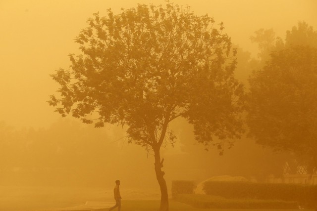 Một người đàn ông đi trong bão cát ở Dubai.