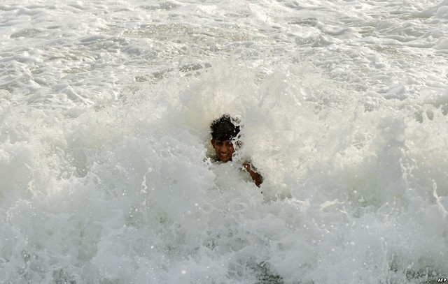 Một cậu bé thích thú vui đùa với sóng nước tại bãi biển ở Colombo, Sri Lanka.