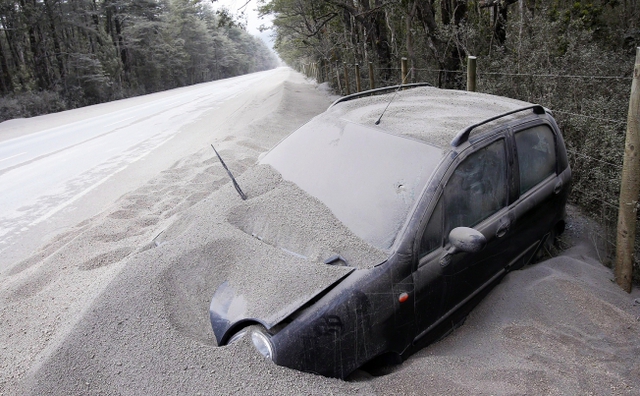 Một chiếc xe bên lề đường bị bao phủ bởi tro bụi phun trào từ miệng núi lửa Calbuco gần thị trấn Ensenada, Chile.