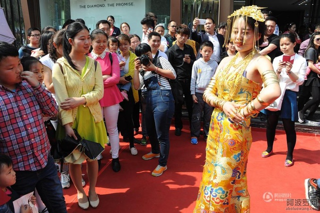 Một cô người mẫu quảng cáo người đeo đầy vàng, quảng bá cho sự kiện của công ty trang sức.