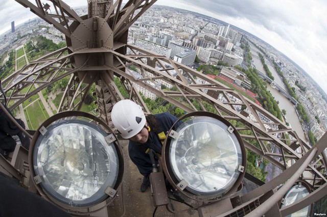 Nhân viên kỹ thuật thay các bóng đèn chiếu sáng trên tháp Eiffel ở Paris, Pháp. Công việc thay và vệ sinh 425 đèn chiếu sáng trên tòa tháp này được thực hiện 4 năm/lần.