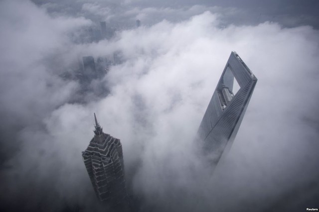 Tòa nhà Trung tâm thương mại thế giới Thượng Hải (phải) và tháp Jin Mao bị bao phủ bởi mây trước một trật mưa ở Thượng Hải, Trung Quốc.