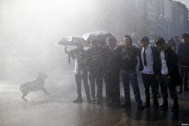 Sinh viên khoác vai nhau trước vòi rồng phun nước của cảnh sát trong cuộc biểu tình yêu cầu cải cách hệ thống giáo dục ở Santiago, Chile.