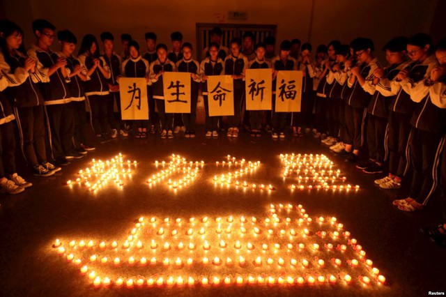 Học sinh tại một trường học ở thành phố Chư Kỵ, Trung Quốc, thắp nến cầu nguyện cho các nạn nhân thiệt mạng trong vụ chìm tàu trên sông Dương Tử.