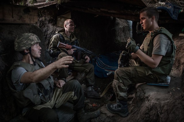 Các tay súng ly khai thân Nga ngồi nghỉ ngơi dưới đường hào ở Mariinka, Donetsk, miền đông Ukraine.