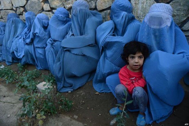 Những người phụ nữ và trẻ em Hồi giáo ngồi chờ nhận thực phẩm từ một địa điểm phân phát trong tháng lễ Ramadan Herat, Afghanistan.