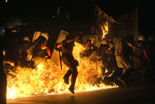 Cảnh sát chạy tránh bom xăng do người biểu tình chống chính sách khắc khổ ném ra trên đường phố ở Athens, Hi Lạp.
