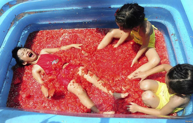 Trẻ em thích thú tắm trong nước dưa hấu để giải nhiệt tại một công viên giải trí ở thành phố Hàng Châu, Trung Quốc.