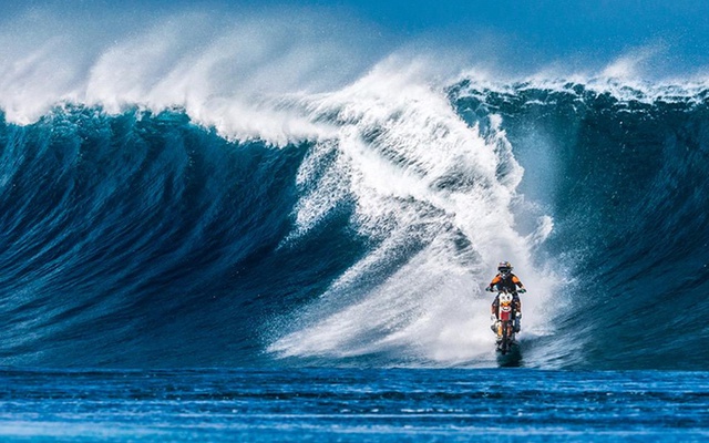 Tay đua biểu diễn Robbie Maddison cưỡi mô tô lướt ván qua một cơn sóng mạnh ở ngoài khơi đảo Tahiti.