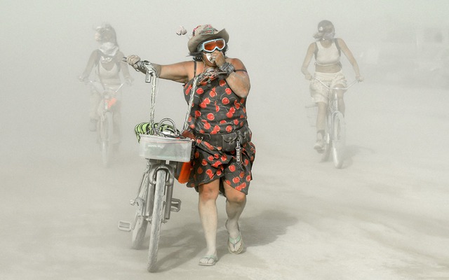 Mọi người đi trong bụi cát để tới tham dự lễ hội Burning Man được tổ chức trên sa mạc Đá Đen ở Nevada, Mỹ.