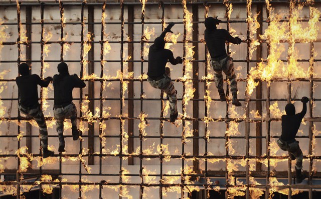Cảnh sát đặc nhiệm Ả-rập Xê-út trình diễn kỹ năng leo hàng rào lửa trong một lễ diễu binh tại thành phố Mecca.