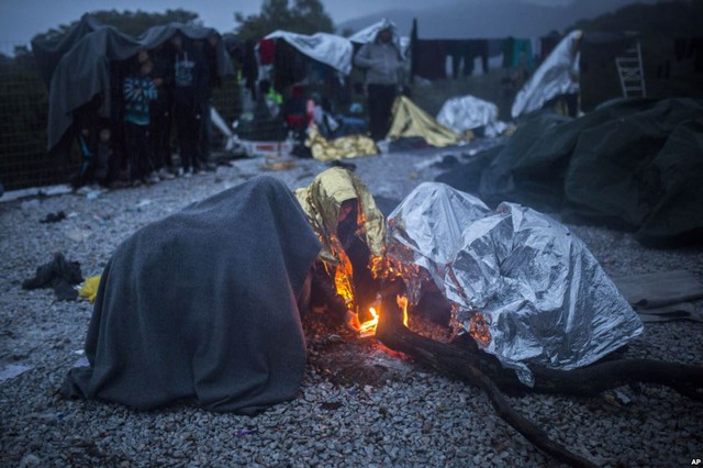Người di cư trùm chăn nhiệt trong khi cô gắng đốt lửa để sưởi ấm tại ngôi làng Skala Sikaminias trên đảo Lesbos, Hi Lạp.