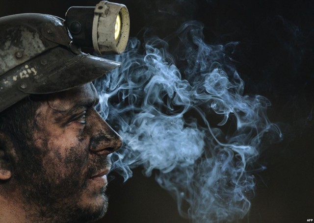 Công nhân ngồi nghỉ ngơi sau khi kết thúc ca làm việc tại mỏ than ở thành phố Petrila, Romania.