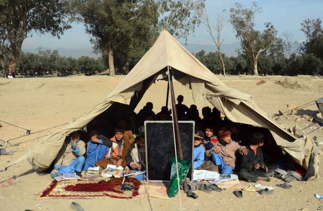 Trẻ em tham ngôi trong lều tạm tham dự lớp học ngoài trời ở ngoại ô thành phố Jalalabad, Afghanistan.