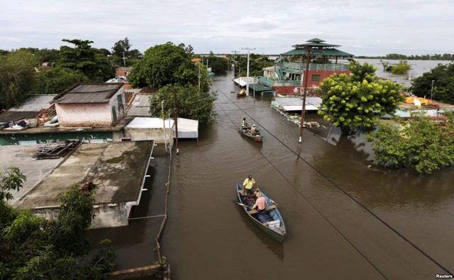 Người dân di chuyển bằng thuyền gần những ngôi nhà ngập lụt ở thành phố Asuncion, Paraguay.