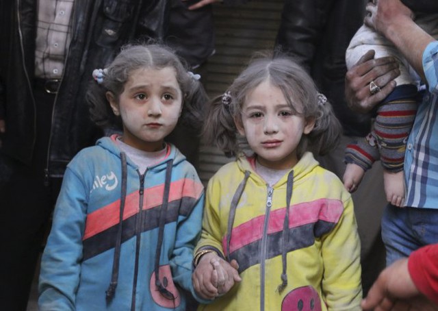 
Hai bé gái sống sót nắm chặt tay nhau sau một vụ tấn công tên lửa đất đối đất tại quận Bab al-Hadeed, thành phố Aleppo ở Syria ngày 7-4. Các nhà hoạt động cho rằng cuộc tấn công do các lực lượng trung thành với Tổng thống Bashar al-Assad gây ra.

