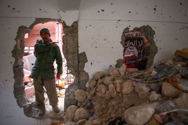 Một chiến binh Peshmerga (lực lượng chiến đấu chống IS của người Kurd) dẫn lối vào đường hầm bên trong thành phố Sinjar, Iraq - Ảnh: The Wall Street Journal