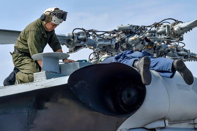 
Các nhân viên trên tàu USS Lassen kiểm tra, sửa chữa 1 máy bay MH-60R hôm 26/10. Ảnh: Huanqiu
