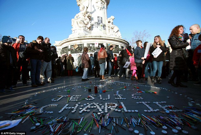 Hàng chữ Je suis Charlie được xếp bằng nến, xung quanh là bút và bút chì, tại quảng trường Place de Republique.