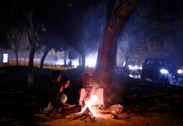 Mọi người sưởi ấm quanh một đống lửa ở New Delhi, Ấn Độ.