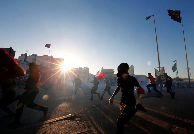 Người biểu tình chạy khỏi cảnh sát chống bạo động ở thành phố Bilad Al Qadeem, Bahrain.
