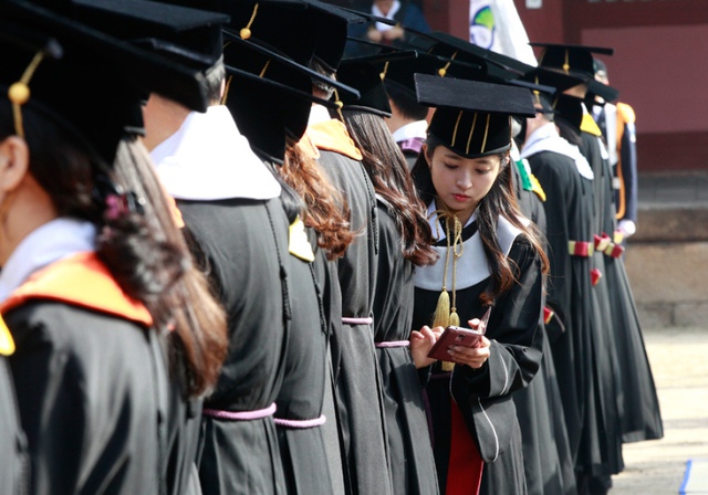 Nữ sinh viên kiểm tra điện thoại di động trong lễ tốt nghiệp tại trường đại học Sungkyunkwan ở Seoul, Hàn Quốc.