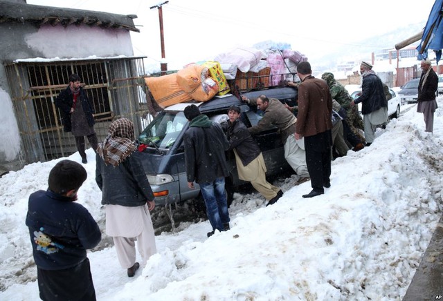 Những người đàn ông đẩy chiếc ô tô mắc kẹt trong băng tuyết tại tỉnh Panjshir, Afghanistan.