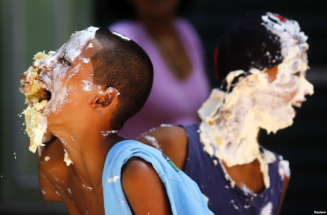 Trẻ em thích thú bôi bánh kem lên mặt trong lễ kỷ niệm 450 thành lập thành phố Rio de Janeiro, Brazil.