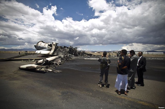 Các quan chức sân bay kiểm tra xác một chiếc máy bay vận tải quân sự bị phá hủy trong đợt không kích do Ả-rập Xê-út đứng đầu nhằm vào sân bay quốc tế Sanaa, Yemen.