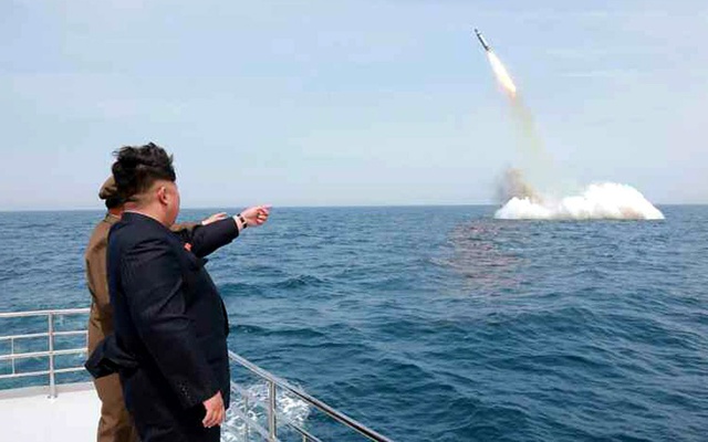 Nhà lãnh đạo Triều Tiên Kim Jong-un quan sát một tên lửa hành trình được phóng đi từ tàu ngầm gần đảo Sinpo ở phía đông bắc nước này.