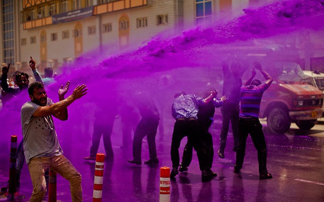 Cảnh sát phun nước màu vào người biểu tình phản đối chính phủ trên đường phố ở Srinagar, Ấn Độ.