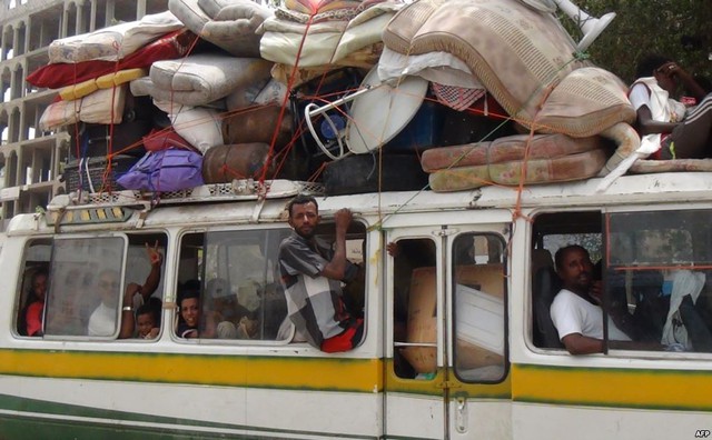 Người dân ngồi trên xe bus chở đầy đồ đạc trong khi chạy khỏi cuộc chiến giữa quân đội chính phủ và phiến quân Huthi tại thành phố cảng Aden, Yemen.